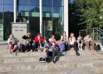 Grupa młodzieży siedzi na schodach Teatru Ludowego im. Ludwika Solskiegow Tarnowie