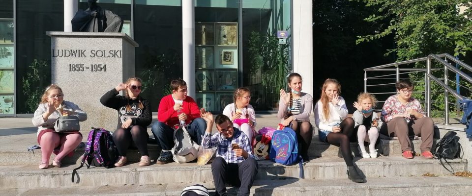 Grupa młodzieży siedzi na schodach Teatru Ludowego im. Ludwika Solskiegow Tarnowie