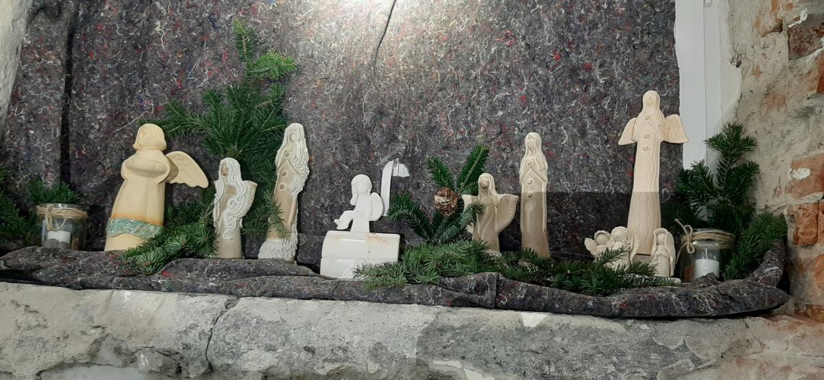 Wyroby gliniane ustawione na stole udekorowanym korą drzewa.