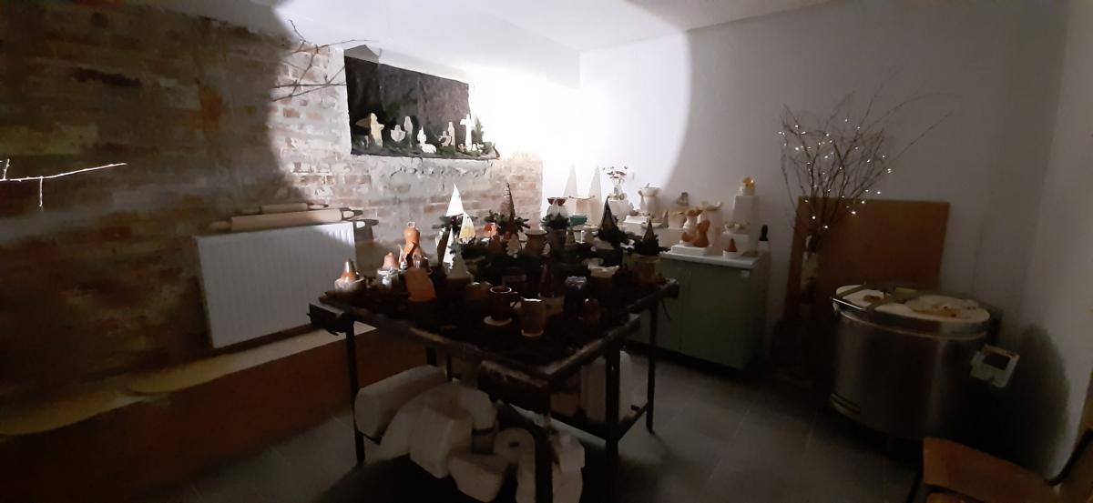 Wyroby gliniane ustawione na stole udekorowanym korą drzewa.