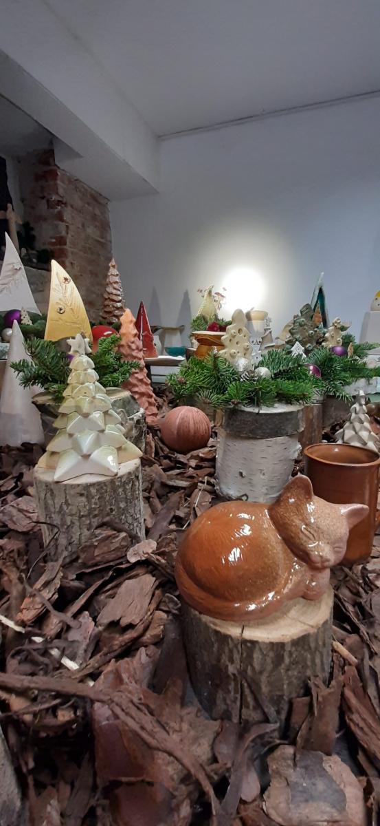 Wyroby gliniane ustawione na stole udekorowanym korą drzewa.