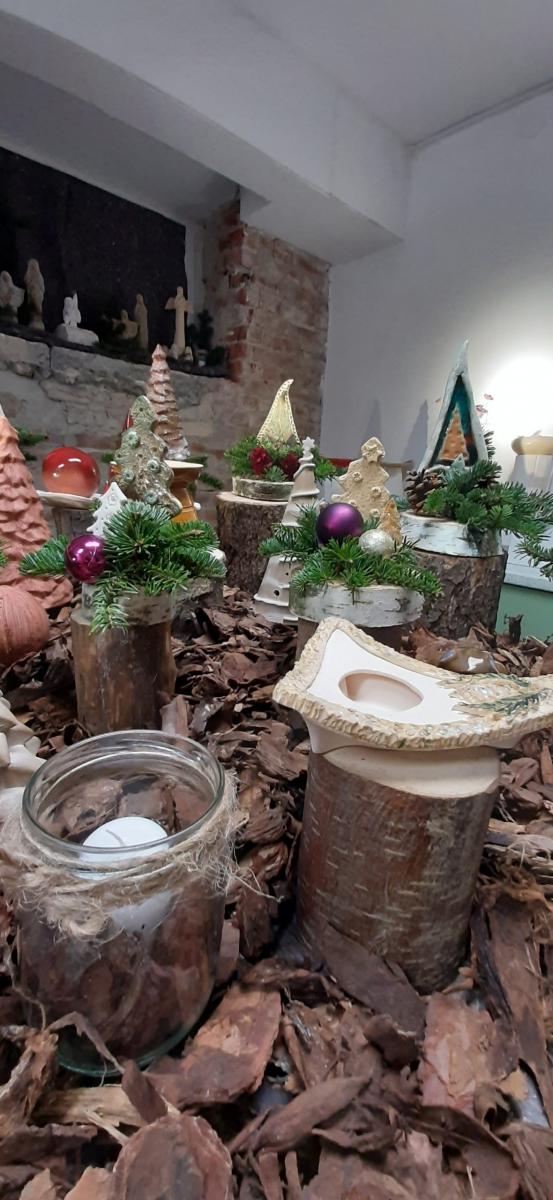 Wyroby gliniane ustawione na stole udekorowanym korą drzewa.