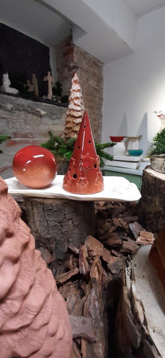 Wyroby gliniane ustawione na stole udekorowanym korą drzewa.