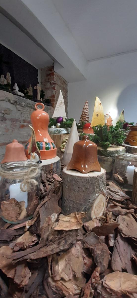 Wyroby gliniane ustawione na stole udekorowanym korą drzewa.