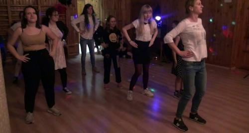 Grupa dziewcząt tańczy.