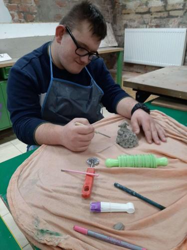 chłopiec formuje glinianego baranka