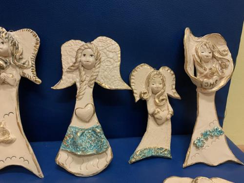 Cztery gliniane aniołki na granatowym tle.