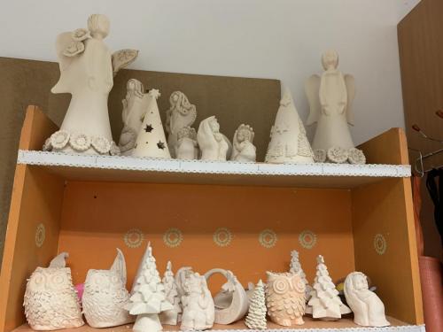 Na półkach stoją figurki ceramiczne o tematyce Bożego Narodzenia.