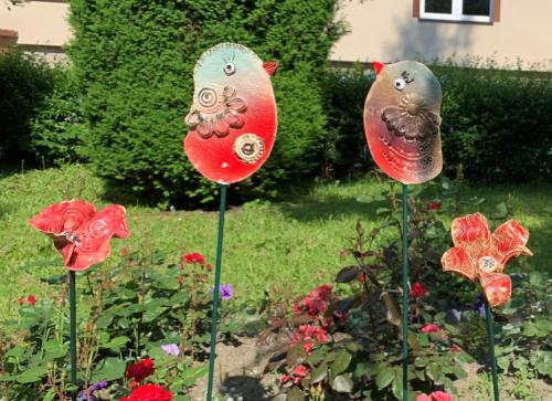 Ceramiczne ozdoby ogrodowe: ptaszki i motylki.