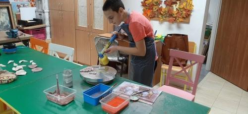 Chłopiec wykonuje ozdoby gliniane.