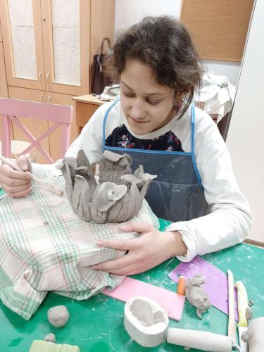 Dziewczynka rzeźbi w glinie.