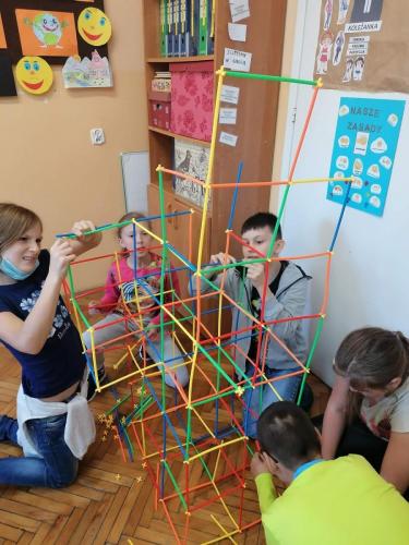 Dzieci układają budowle z patyczków.