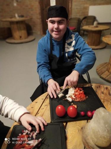 Chłopiec kroi na desce pomidory.