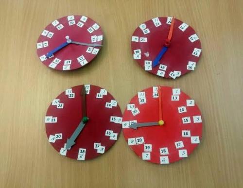 Cztery czerwone zegary leża na stole.